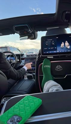 a man sitting in the driver's seat of a car with his feet up