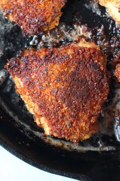 three pieces of fried meat in a frying pan