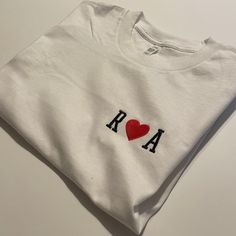 a white t - shirt with the word roma on it and a heart in the middle