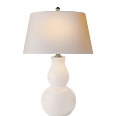 a white table lamp with a beige shade