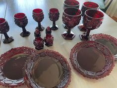 a table topped with lots of red glass dishes