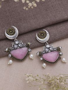 Dive into the realm of sophistication and charm with our Dual Tone Pink Chandbali Earrings, a harmonious blend of tradition and contemporary flair. These earrings boast a graceful design adorned with exquisite half-moon detailing, showcasing the artisanal finesse that makes them a true embodiment of elegance. The dual tone pink color palette imparts a refreshing and playful vibe, making them a versatile accessory that effortlessly transitions from day to night, from casual gatherings to festive celebrations. Meticulously crafted with precision, these earrings not only serve as a visual delight but also symbolize a timeless statement piece. Elevate your style effortlessly as you embrace the fusion of classic and modern aesthetics, allowing these Dual Tone Pink Chandbali Earrings to become a Brass Chandbali Bridal Earrings, Silver Dual-tone Chandbalis For Festivals, Silver Kundan Chandelier Earrings With Intricate Design, Festive Brass Chandbalis With Matching Earrings, Oxidized Finish Earrings For Wedding And Diwali, Fusion Chandbali Jewelry For Eid, Fusion Style Chandbali Jewelry For Eid, Silver Brass Chandelier Earrings For Wedding, Temple Jewelry Earrings With Oxidized Finish For Wedding