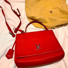 Lv Lock 2 Me Red Handbag/Crossbody/Shoulder/ Includes Removable Red Strap. Comes With Lv Dust Bag And Her Coa (Certificate) Upon Purchase. This Bag Is A Beauty ! Grade A Condition High-end Red Shoulder Bag, High-end Red Bag With Detachable Handle, High-end Red Crossbody Bag, High-end Red Bag With Removable Pouch, High-end Red Crossbody Shoulder Bag, High-end Red Shoulder Bag With Double Handle, High-end Red Shoulder Bag With Detachable Handle, Red Luxury Shoulder Bag With Branded Hardware, Designer Red Bag With Branded Hardware