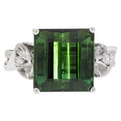 This classy piece would pair perfectly with everything in your wardrobe. Made with an exquisitely cut Emerald shape Green Tourmaline, this stone displays high clarity and is an excellent accessory. Accented with 0.48 ct of diamonds, this ring is an amazing adornment. Luxury Tourmaline White Gold Jewelry, Gia Certified Tourmaline Rings For Formal Occasions, Elegant Emerald-cut Tourmaline Ring, Elegant Emerald Cut Tourmaline Ring, Luxury Tourmaline Gemstones With Accent Stones, Elegant Emerald Gemstones With Accent Stones, Elegant Green Sapphire Ring Gia Certified, Elegant Tsavorite Gemstones For Anniversary, Formal Emerald Cut Tsavorite Gemstone