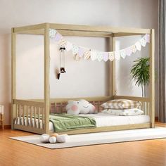 a child's bedroom with a canopy bed and pillows on the floor next to a potted plant