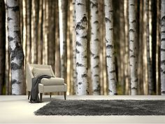 a chair sitting on top of a rug in front of a forest filled with trees