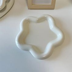 a white plate sitting on top of a table next to a framed photo and mirror