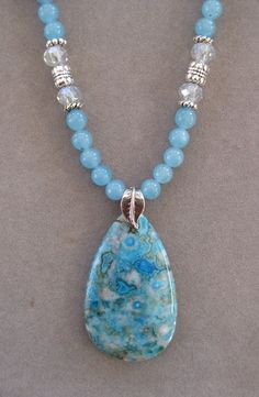 This is a beautiful teardrop Turquoise Crazy Lace Agate Pendant Necklace. These stones are very rare and hard to find. It is 16 inches long and adjustable to 21 inches with a lobster clasp and chain. The pendant measures 2 inches long by 1 1/4 inches wide. The beads in the chain are Blue Agate and match the pendant stone.  All my jewelry is unique and one of a kind. Similar quality jewelry is priced at double. I source the stone pendants from all over the world. All pendants and necklaces are made with semiprecious stones and beads. I spend hours coordinating the pendants with the semiprecious stone, pearls or crystal beads. Many of the stones are crazy lace agate, dragon vein agate, agate, malachite, jade, African bloodstone, kambaba, obsidian, bornite, sea sediment, cherry quartz and man Luxury Blue Agate Beaded Necklaces, Turquoise Teardrop Agate Jewelry, Turquoise Agate Teardrop Jewelry, Blue Turquoise Teardrop Necklace With Gemstone Beads, Adjustable Teardrop Turquoise Necklace With Natural Stones, Adjustable Teardrop Gemstone Beaded Necklaces, Teardrop Agate Gemstone Beads Necklace, Agate Gemstone Beads Teardrop Necklace, Agate Stone Jewelry