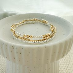 stack of three bracelets | 2.5mm - 4mm 14k gold filled beads | 2.5mm sterling silver beads | strung on high quality elastic string | some sizes may have one/two extra beads incorporated into the pattern to achieve the proper size, it is unnoticeable unless you count all the beads in the pattern This classic beaded bracelet stack pulls together silver girls + golden girl vibes. One patterned silver + gold beaded bracelet One 2.5mm gold beaded bracelet One 2.5mm silver beaded bracelet Gold And Silver Beaded Bracelets, Bracelet Stack Gold, Silver Beaded Bracelets, Mixed Metal Bracelet, Beaded Bracelet Stack, Mixed Metal Bracelets, Single Bracelet, Gold Beaded Bracelet, Silver Beaded Bracelet