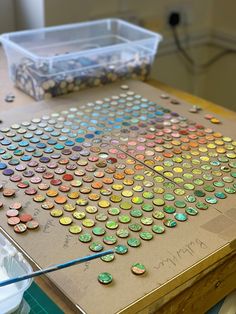 there are many different colored buttons on the table and one has a paintbrush in it