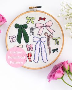 the embroidery pattern is being displayed in front of pink flowers and white wall hangings