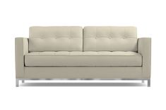 a white couch sitting on top of a wooden floor next to a metal legrest