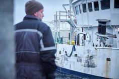 a man standing next to a boat in the water