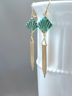 Textured Front, Hollow Back This listing is for a pair of long Art Deco style dangle earrings. They feature green and gold Czech glass beads and long lightweight brass Deco style pendants.  The brass pendants have a ribbed texture on the front and they are hollow on the back (SEE 2nd PHOTO). The textured Czech beads are shaped like fans; one of the most popular design motifs during the 1920s and 1930s.  The earrings measure 3 1/2 inches long and hang from gold plated lever back ear wires.  See more 1920s Flapper style earrings here: https://www.etsy.com/shop/BohemeBijou?ref=l2-shopheader-name&section_id=21739992 ABOUT THIS COLLECTION What are the three style essentials Jazz Age flappers like Clara Bow, Louise Brooks, and Zelda Fitzgerald have in common? Red lipstick, bobbed haircuts, and f Bobbed Haircuts, Jewellery Drawing, Zelda Fitzgerald, Long Art, Clara Bow, Brass Pendants, Design Motifs, Louise Brooks, Style Essentials