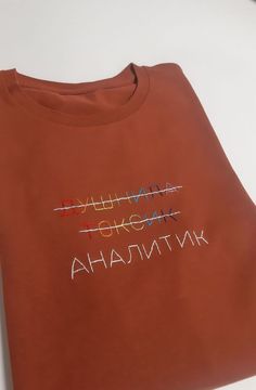 an orange t - shirt that has the words in different languages written on it,