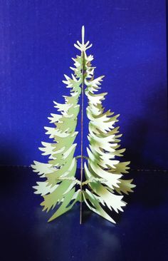 a paper christmas tree on a blue background