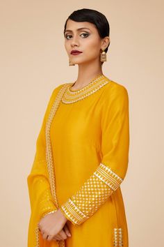 Turmeric yellow long sleeves A-line kurta in chanderi base with round neckline and floral tonal jaal sequin embroidery. Paired with ivory churidar and floral aari work with sequin highlights viscose organza dupatta.
Components: 3
Pattern: Embroidery
Type Of Work: Aari Work With Sequins and Zari
Neckline: Round
Sleeve Type: Long
Fabric: Kurta: Chanderi, Dupatta: Viscose Organza, Churidar: Cotton
Color: Yellow
Other Details: 
Length:
Kurta: 46inches
Churidar: 58inches
Dupatta: 2.5metres
Occasion: Embroidered Anarkali Palazzo Set With Long Sleeves, Embroidered Long Sleeve Palazzo Set For Diwali, Yellow Bollywood Traditional Wear For Transitional Season, Chanderi Palazzo Set With Resham Embroidery And Long Sleeves, Bollywood Style Embroidered Long Sleeve Palazzo Set, Festive Mustard Straight Kurta Set, Designer Gold Long Sleeve Dress, Designer Long Sleeve Sets For Diwali, Transitional Yellow Dress With Resham Embroidery