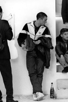 black and white photograph of men sitting on steps with beer bottles in front of them