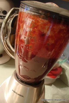 a blender filled with red liquid on top of a counter