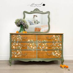 an old dresser with flowers painted on it and a mirror over the top that is next to it