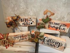 four wooden signs with bows and pumpkins on them sitting on top of each other