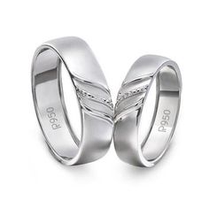 two white gold wedding rings with diamonds on each one and the word love written in cursive writing