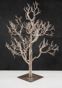 a silver tree sculpture sitting on top of a table