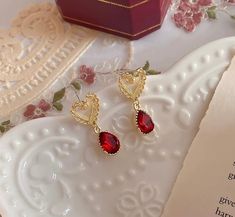 Valentine's Day romantic vibes, dainty heart shaped gold lace stud with red ruby dangle earrings. Stunning red zircon gemstones show elegant, classy and lovely sparkles. Perfect for your dates, happy time out or a accent spice to elevate your style! 💎 Features: ♥ Material: Gold plated bronze and sterling silver ♥ Main stone: Red ruby zircon ♥ Push back Closure 💎 Details: ♥ Approximate Measurements: - Length: 3 cm ♥ Lightweight, easy to wear ♥ Nickel/Lead Free, Hypoallergenic 🎁 Packing & Shipping: ♥ All our jewelry will be shipped with beautiful gift wrap packaging ♥ Handwrite gift notes/cards available upon request ♥ SAME DAY & FREE US Domestic Shipping available ♥ International customers: We ship worldwide! But we are not responsible for customs duties/taxes. 💎 Thank you for your supp Elegant Earrings For Valentine's Day Party, Elegant Party Earrings For Valentine's Day, Dainty Earrings For Valentine's Day Party, Dainty Valentine's Day Party Earrings, Elegant Pierced Heart Earrings For Valentine's Day, Heart-shaped Earrings For Mother's Day Party, Heart Earrings For Mother's Day Party, Valentine's Day Teardrop Heart Earrings For Pierced Ears, Mother's Day Heart Earrings For Party