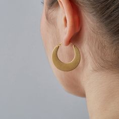 A crescent shaped take on the classic gold hoop or creole earring, drawing influences from both tribal and 1970s jewellery. Hoop earrings are always popular through the decades in various forms and this is an updated and on-trend version drawing on the current tribal trend (with a bit of influence from 1970s Woodstock style!) The half moon shapes are cut from raw brass, giving them their slightly matte gold finish. They are fixed to ear wires with a 45 degree hook-and-hole fastening so they're e Everyday Crescent Single Earring, Minimalist Crescent Hoop Earrings, Gold Moon Shaped Hoop Earrings, Gold Moon-shaped Metal Hoop Earrings, Gold Crescent Hoop Earrings For Everyday, Gold Moon Shaped Metal Hoop Earrings, Everyday Gold Crescent Hoop Earrings, Minimalist Moon-shaped Pierced Hoop Earrings, Minimalist Semi-circle Hoop Earrings As Gift