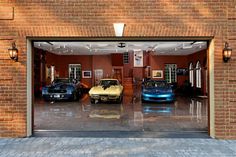 two cars are parked in the garage with their doors open and one car is blue