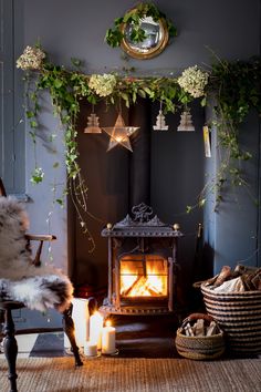 a room with a fireplace, chair and potted plants