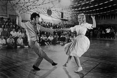 two people dancing on a dance floor in front of an audience