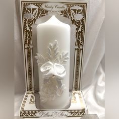 a white candle with a bow on it