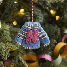 an ornament hanging from a christmas tree decorated with blue and pink knitted mittens