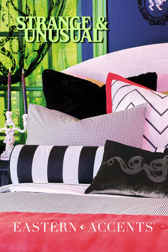 a bed with black and white pillows on it