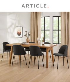 a dining room table with chairs and a vase on it in front of a window