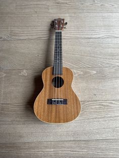 an ukulele sitting on top of a wooden floor