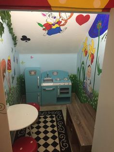 this is a child's playroom with an oven, stove and table in it