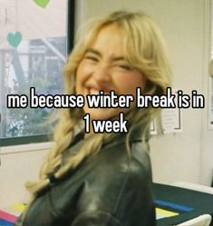 a woman sitting in front of a window with the words me because winter break is in i