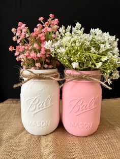 two mason jars with pink and white flowers in them