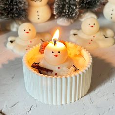 a candle that is sitting in some kind of cupcake with snowmen around it