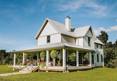 a large white house sitting on top of a lush green field