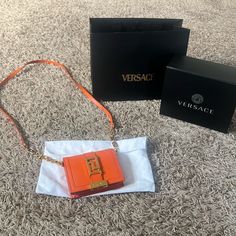 Versace Orange Calfskin Wallet On Chain! Comes With Shopping Bag, Box, And Dust Bag! Odor Free And Kept In A Smoke Free Home! Excellent Condition, Has Very Faint Scratches On Hardware (Not Visible To Eyes) And Corners Have Some Smudging. Orange Evening Bag With Chain Strap, Designer Wallet On Chain With Branded Hardware, Designer Orange Bags As Gifts, Designer Orange Bags For Gifts, Luxury Rectangular Wallet On Chain As Gift, Leather Rectangular Wallet On Chain For Gift, Rectangular Leather Wallet On Chain For Gift, Rectangular Wallet On Chain Gift, Designer Party Wallet On Chain In Rectangular Shape