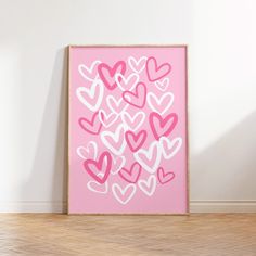 a pink and white painting with hearts on it in front of a wood flooring area