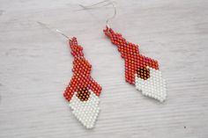 Red Holiday Gnomes, perfect for adding a fun and quirky element to your look, these earrings are sure to turn heads and spark conversations. Bead woven with delica beads one bead at a time.  Earrings measure approximately 2 inches long on Sterling Silver Ear wires. Fun and funky specialty jewelry, embrace your playful side and treat yourself to these delightful Red Gnomes earrings today!  They make a great gift or stocking stuffer. Gnomes Earrings, Holiday Gnomes, Gift For Yourself, Earrings Red, Delica Beads, Brick Stitch, Bead Weaving, Jewelry Handmade, Stocking Stuffer