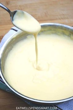 a spoon is pouring batter into a pan