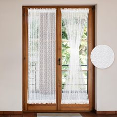 an open door with white curtains and a round rug on the floor