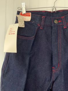 "Rare NWT Vintage Early 80s High Waisted Dark Denim Blue Jeans, by Hush Puppies. New condition and unworn with original tags. Super high rise waist. Front & back pleated down center of leg. Dark denim with red stitching, embroidered back pockets with basset hound logo. Amazing Original condition with original store tags! Brand - Hush Puppies Condition - Original. Deadstock from the 80s, New with original tags 100% Cotton Made in Taiwan Machine Washable Vintage Size - 8 Size - 26\" waist Best Fitted Pre-washed Blue Jeans, Pre-washed Fitted Denim Bottoms, Retro Straight Leg Bottoms With Contrast Stitching, Fitted Dark Wash Pre-washed Bottoms, Retro Fitted Jeans In Rigid Denim, Retro Fitted Rigid Denim Jeans, Fitted Cotton Jeans With Contrast Stitching, Retro High Waist Cotton Jeans, Fitted Pre-washed Denim Bottoms