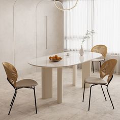 a white table with four chairs and a bowl of oranges on the dining room table