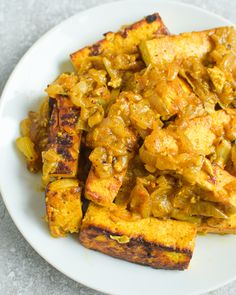 a white plate topped with tofu and onions